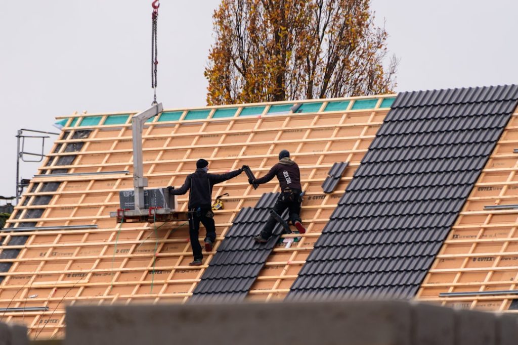 workers-installing-roof-tiles-on-a-new-building-onwxqnebpco