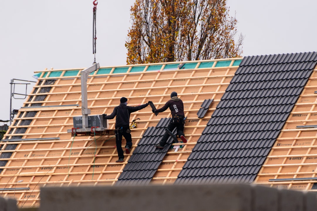 workers-installing-roof-tiles-on-a-new-building-onwxqnebpco